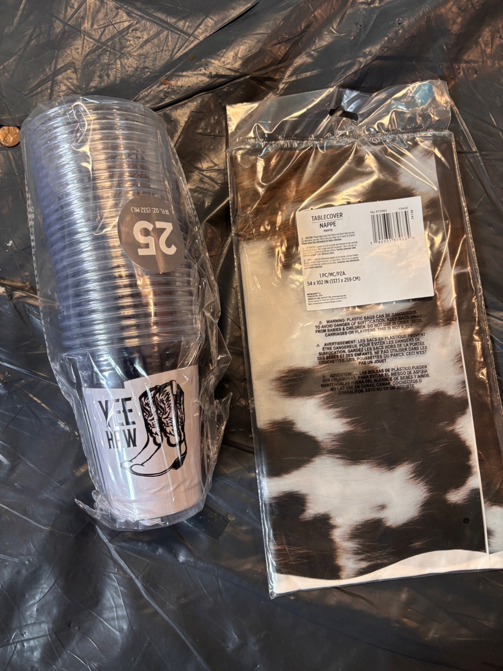 Disposable cow print tablecloth and plastic cowboy boot cups